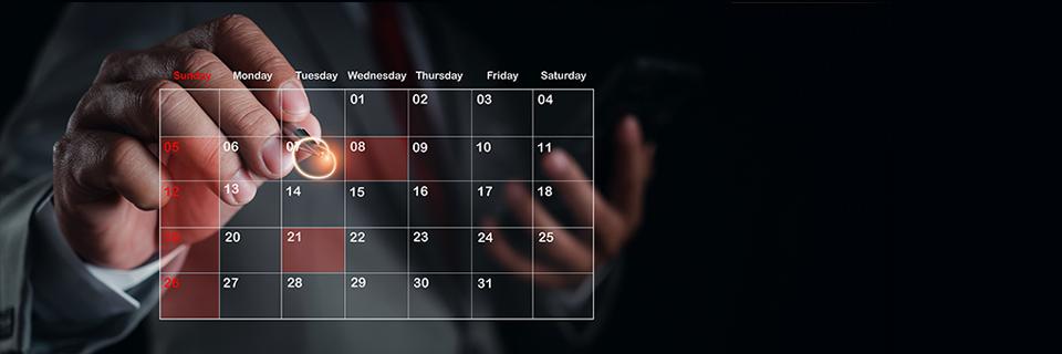A hand circling some important dates on a digital calendar.