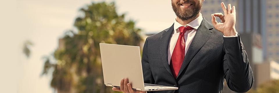 A person in a suit holding a computer.