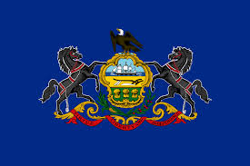 Pennsylvania state flag with coat of arms and state motto; Liberty, Virtue, Independence, on a ribbon on a blue field.