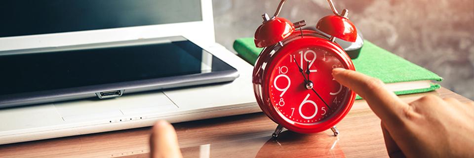 An adjustment of status petitioner pointing at a red alarm clock. 