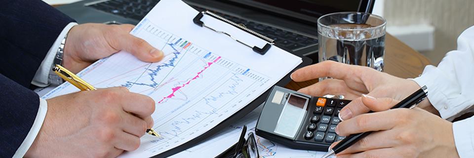 EB-5 investors calculating minimum investment requirements for a Green Card, using project documents and a calculator.