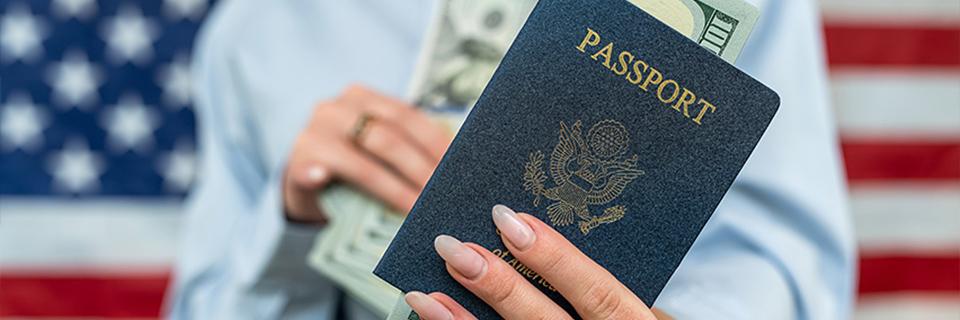A U.S. green card holder holding a passport in hand with dollars in it, symbolizing the path to U.S. citizenship through investment.