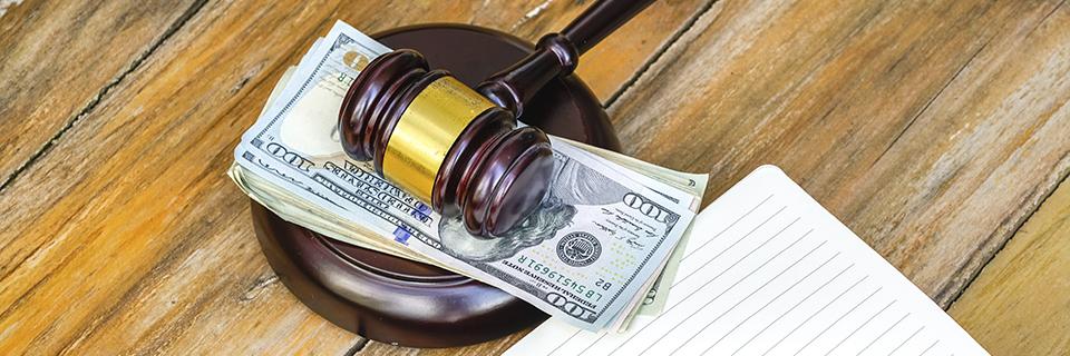 A gavel on money, symbolizing district court regulations regarding lender's funds.