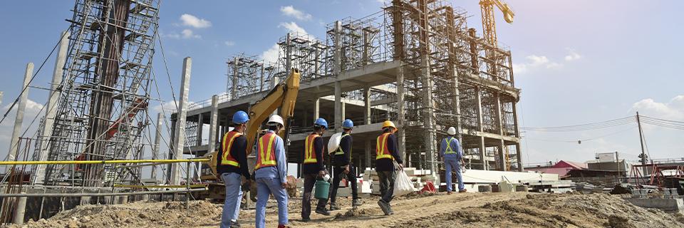 A group of workers in hard hats working on an EB-5 investor visa project site.
