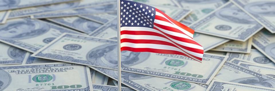 A United States flag on a pile of dollars, concept for investment.