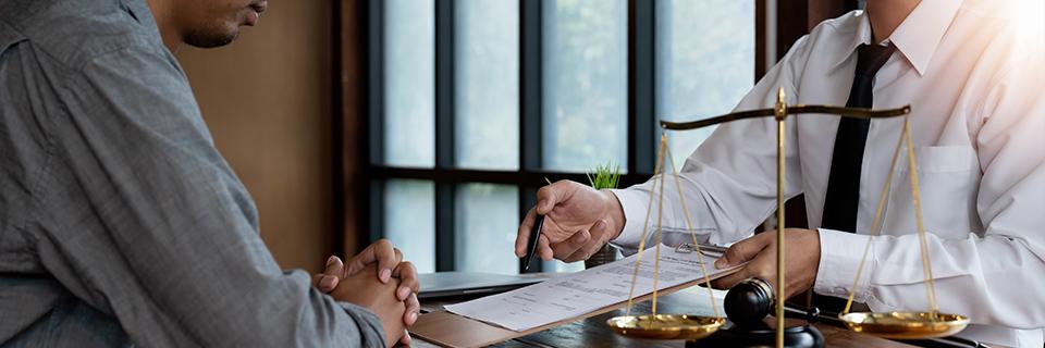 An immigration attorney explaining some green card application documents to their client.