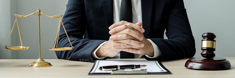 An EB-5 immigration lawyer on their desk with a gavel, scales, and some green card documents.