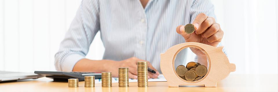 A person counting coins in a piggy bank, calculating the financial viability of real estate development projects.