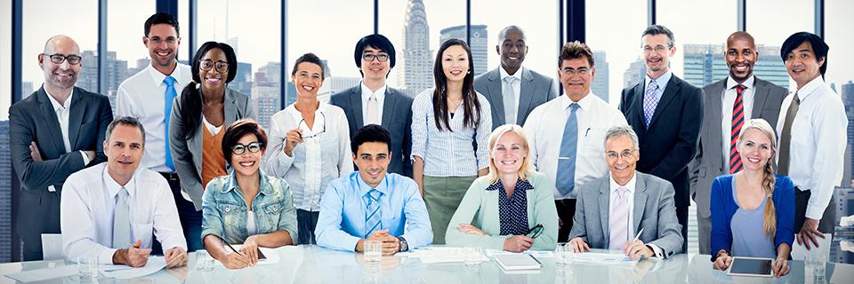 A group of EB-5 experts in an office, smiling at the camera.
