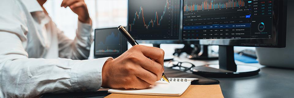 An EB-5 expert working on the source of capital invested in front of multiple screens.