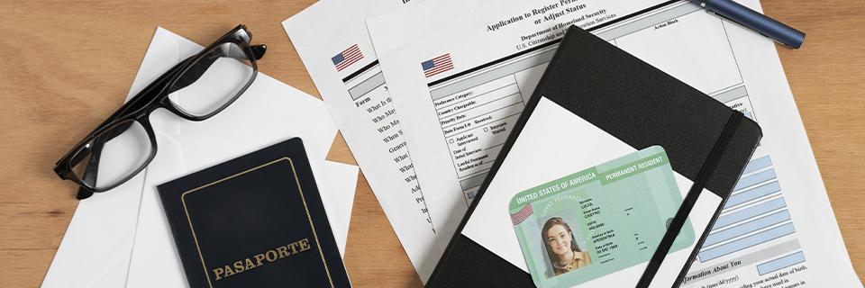 A close-up of several U.S. visa documents, including a passport and a Green Card.