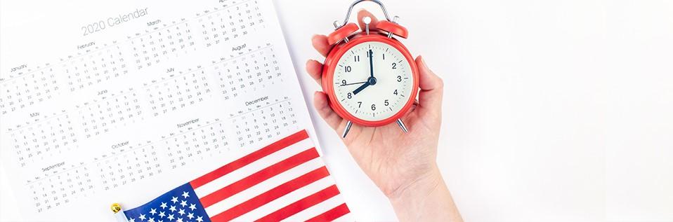 A calendar and an American flag next to a hand holding an alarm clock symbolizing the time LPRs can spend outside the United States.