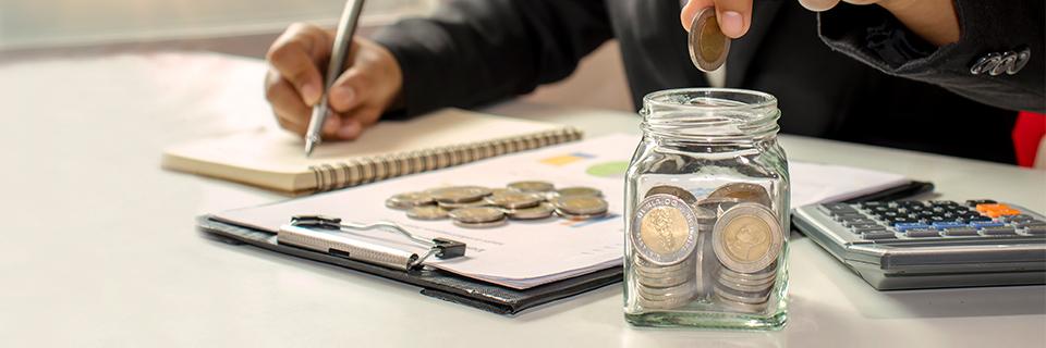 A stack of coins on business documents, and an EB5 investor putting coins in a jar, symbolizing EB5 capital stack.