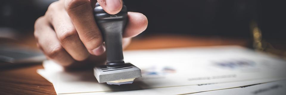 A person stamping a document.