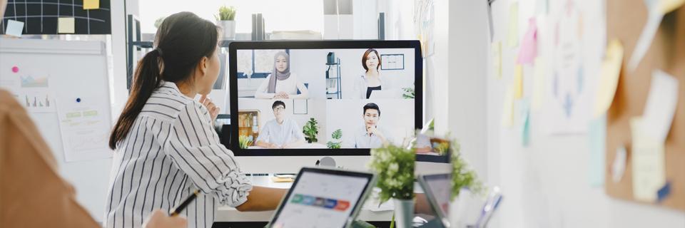 A person sitting at a desk attending a webinar.