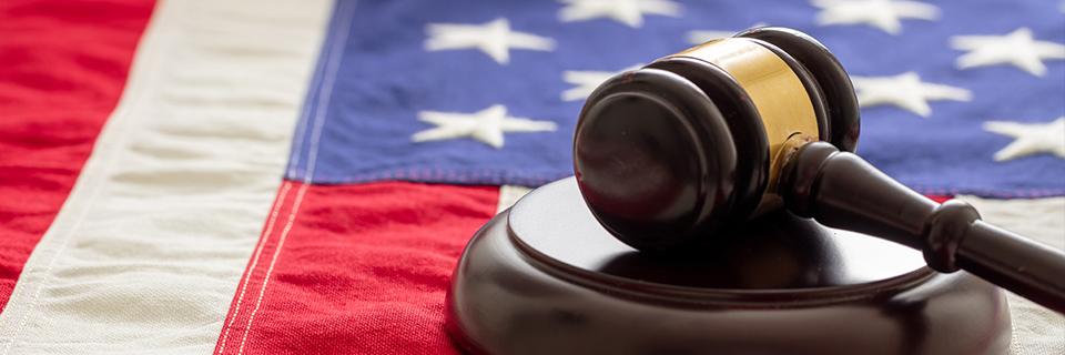 A judge's gavel on top of an American flag.