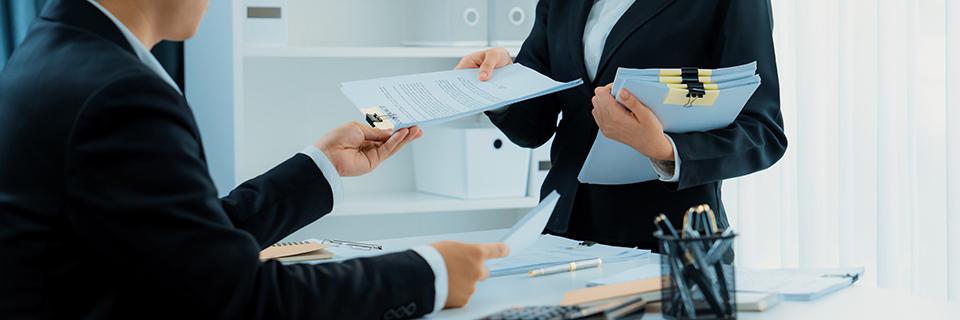 A lawyer handing out an immigrant visa filing form to an alien entrepreneur at an office.