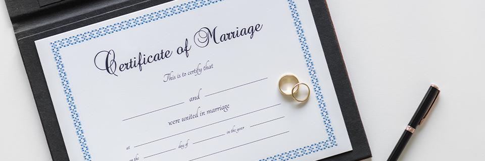 Wedding rings placed on a certificate of marriage.