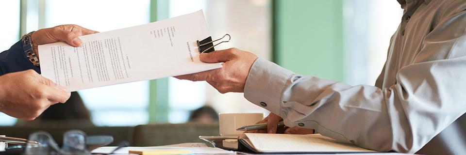 A lawyer handing a Form I-829 to a conditional green card holder as the last step of the EB-5 process.