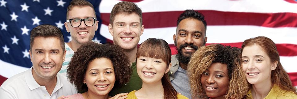 A group of people smiling and posing for a photo in front of the American flag.