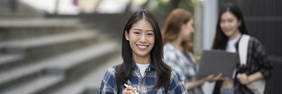 An Asian F-1 student visa holder smiling at the camera.