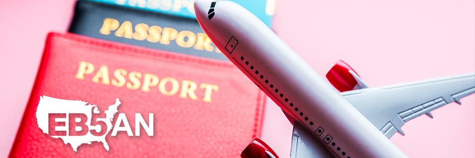 A close up of a model plane in front of some passports with the EB5AN logo on the corner.