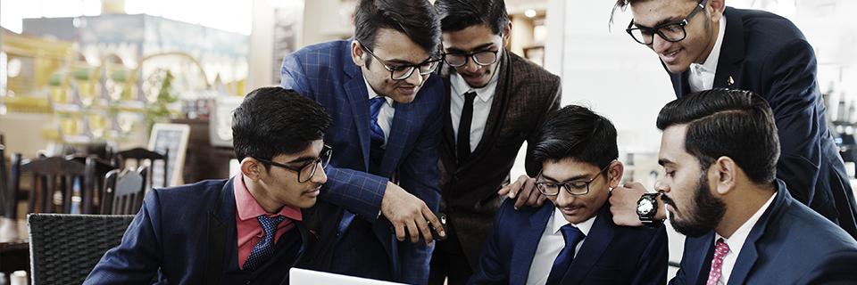 A group of Indian Green Card applicants looking at a computer screen.