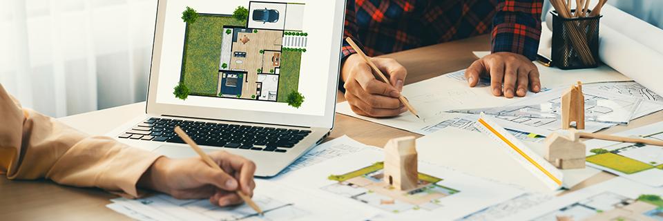 Architects or project developers working on a real estate project plan on a desk.