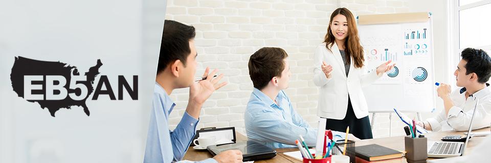 The EB5AN logo next to a group of EB5 visa experts working at an office.