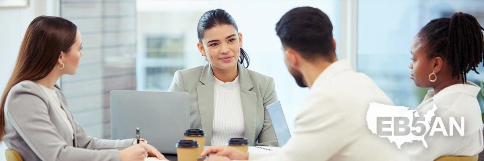 A group of EB5 Green Card applicants talking to Eb5 experts, with the EB5AN logo on the corner.