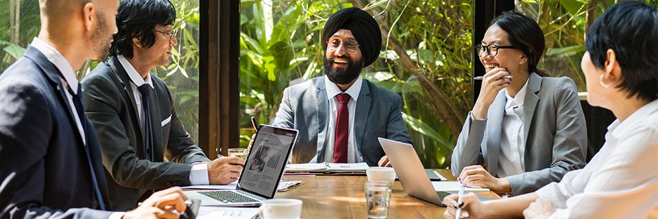 Some Indian EB5 investors sitting with immigrant visa experts at a desk.