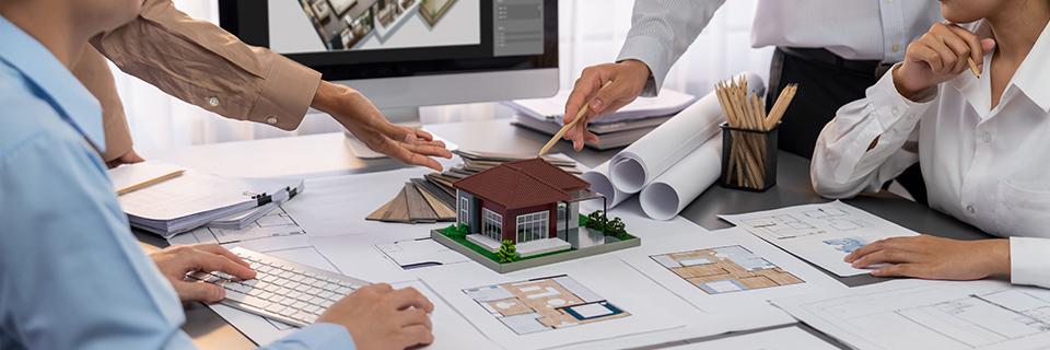 A group of people looking at a model of a house.
