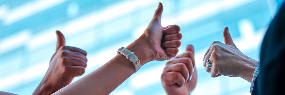 A group of EB5 investors giving thumbs up, symbolizing I-956F approvals.