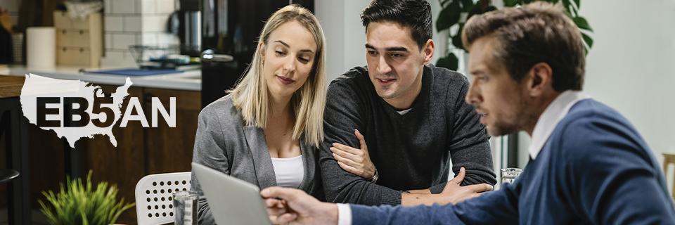 An EB5 regional center principal explaining the EB5 process to some alien entrepreneurs at an office, next to the EB5AN logo.