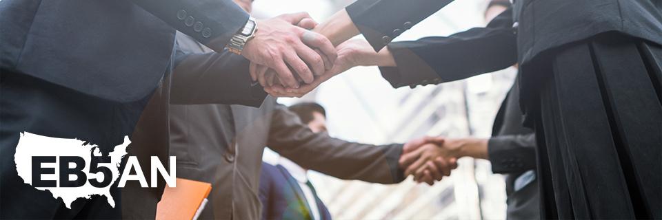 A group of EB5 investors shaking hands with industry experts, with the EB5AN logo on the corner.
