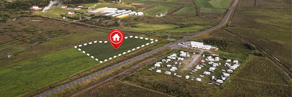 A plot of land marked by a red pin with a house icon on it.