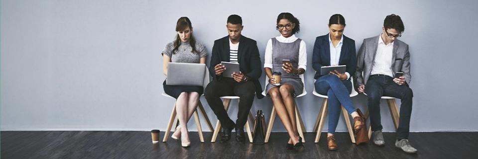 A group of people sitting at a waiting lounge, symbolizing visa backlogs for Indian EB5 applicants.