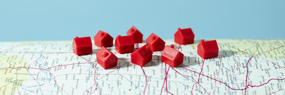 Some red house figures placed on a U.S. map, symbolizing a diverse portfolio through EB5 real estate investment.
