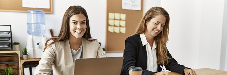 Two professional women working together in an office environment, representing job flexibility and opportunities for EB5 investors in the US.