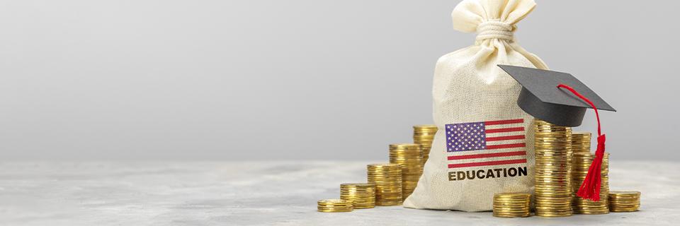 A bag of coins with a U.S. flag and a graduation cap, symbolizing financial aid and educational cost savings possible for EB5 visa holders attending US schools and universities.