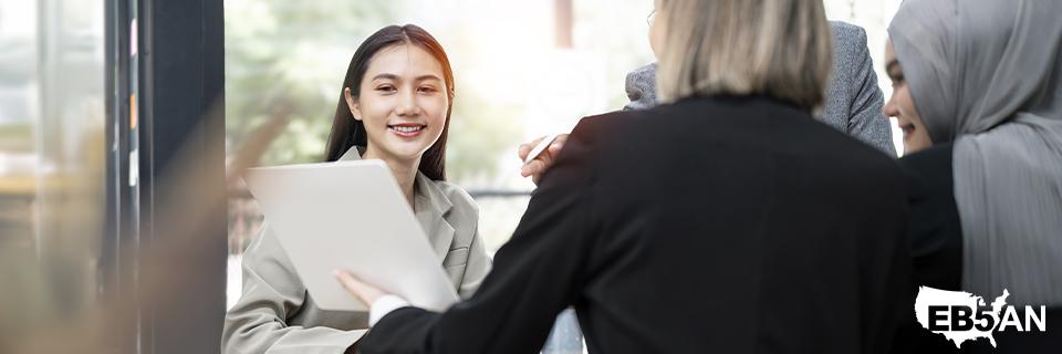Smiling professionals engaged in a discussion, symbolizing collaborative support and expert guidance for EB5 investors seeking U.S. permanent residency with EB5AN.