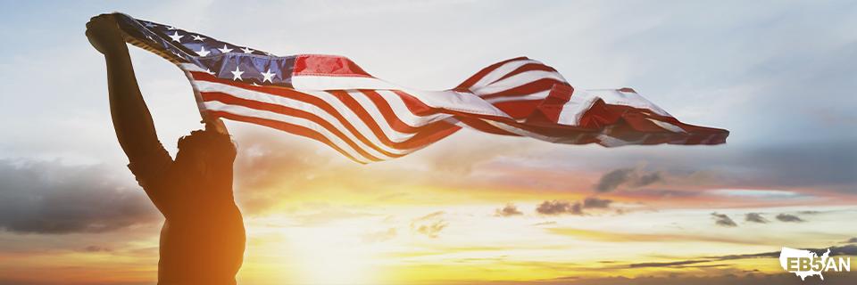 The EB5AN logo next to a person holding the U.S. flag against a beautiful sunset, symbolizing the American dream and opportunities in the United States.