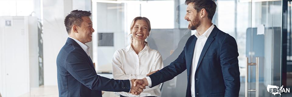 Two business professionals shaking hands in an office, symbolizing a successful EB5 investment agreement. The image represents EB5AN’s role in guiding investors through the EB5 visa process.