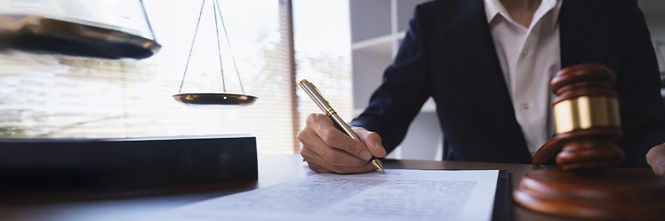 An immigration attorney working on some Eb5 visa documents with a gavel on her desk.