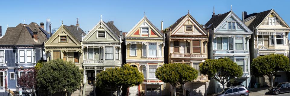 A row of colorful Victorian-style homes in the U.S., representing residential property ownership that can be leveraged through a HELOC for EB5 investments.