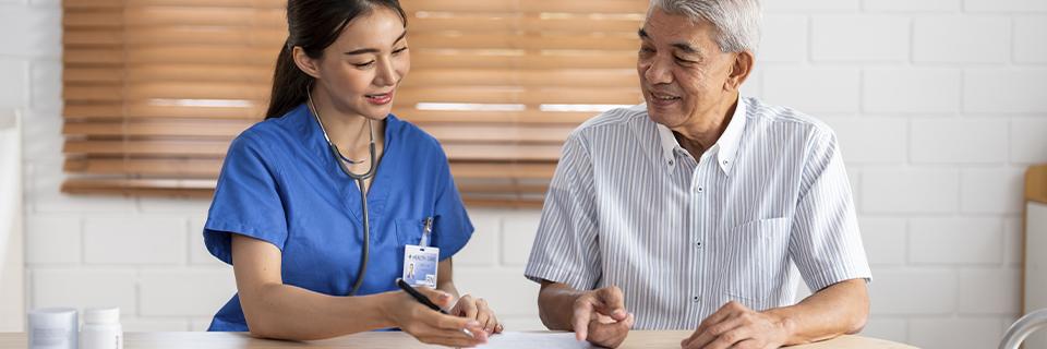 A senior man in conversation with a nurse at a healthcare facility, highlighting the healthcare access available to EB5 retirees living in the U.S.