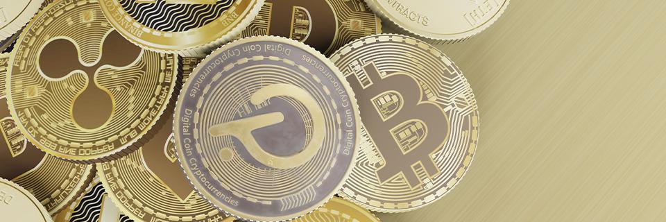 Close-up of various digital currencies including Bitcoin and Ripple, representing the diverse types of cryptocurrency EB5 investors may use to fund their capital investment.