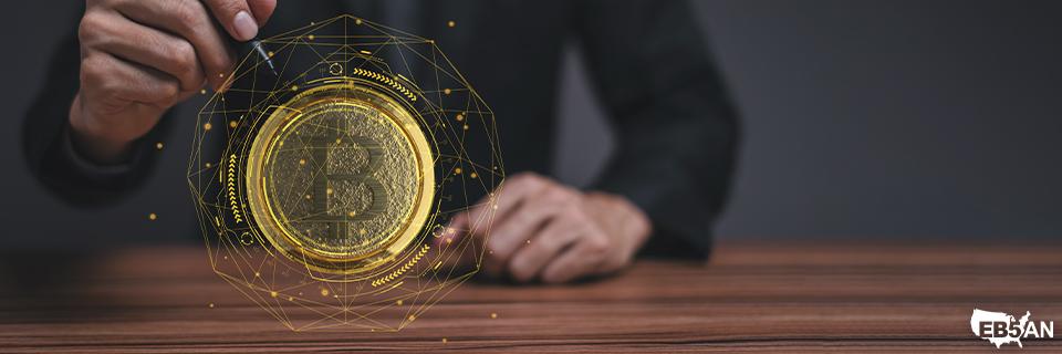 Businessperson holding a glowing digital Bitcoin hologram, reflecting the modern financial technologies used in EB5 investment strategies through EB5AN.