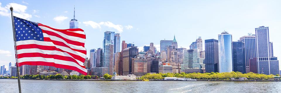 U.S. skyline and American flag symbolizing the EB5 visa pathway for STEM professionals seeking permanent residency and career opportunities.