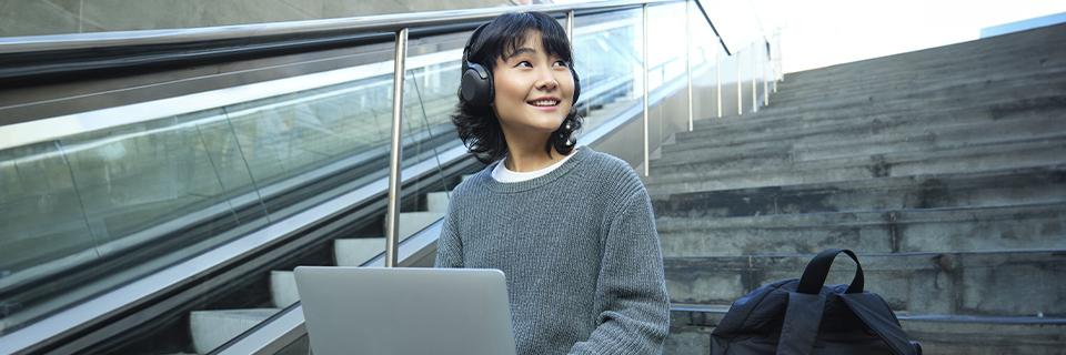 International STEM student in the U.S. using a laptop outdoors, exploring EB5 visa options for career growth and permanent residency.